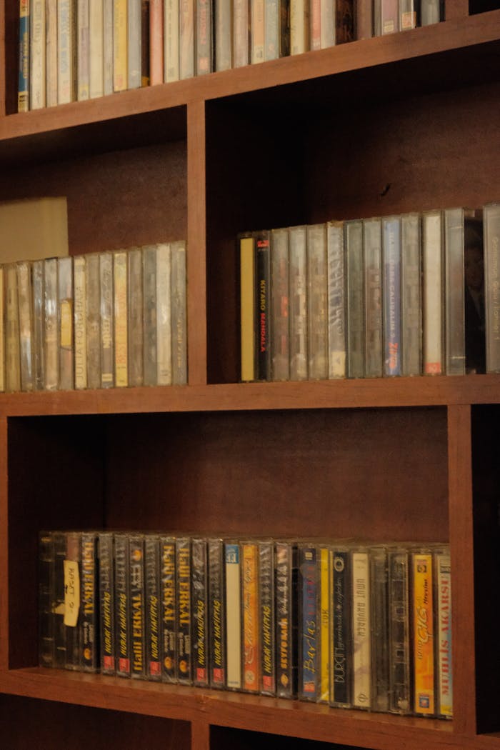 A nostalgic collection of vintage cassette tapes displayed on wooden shelves.