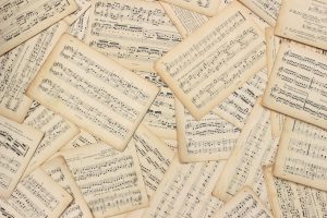 An artistic flat lay of vintage music sheets with a classic touch.