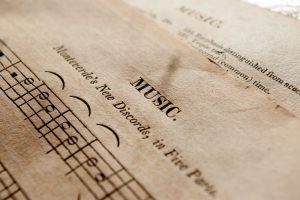 Detailed view of antique music sheets featuring notes and Monteverde's New Discords in sepia tone.