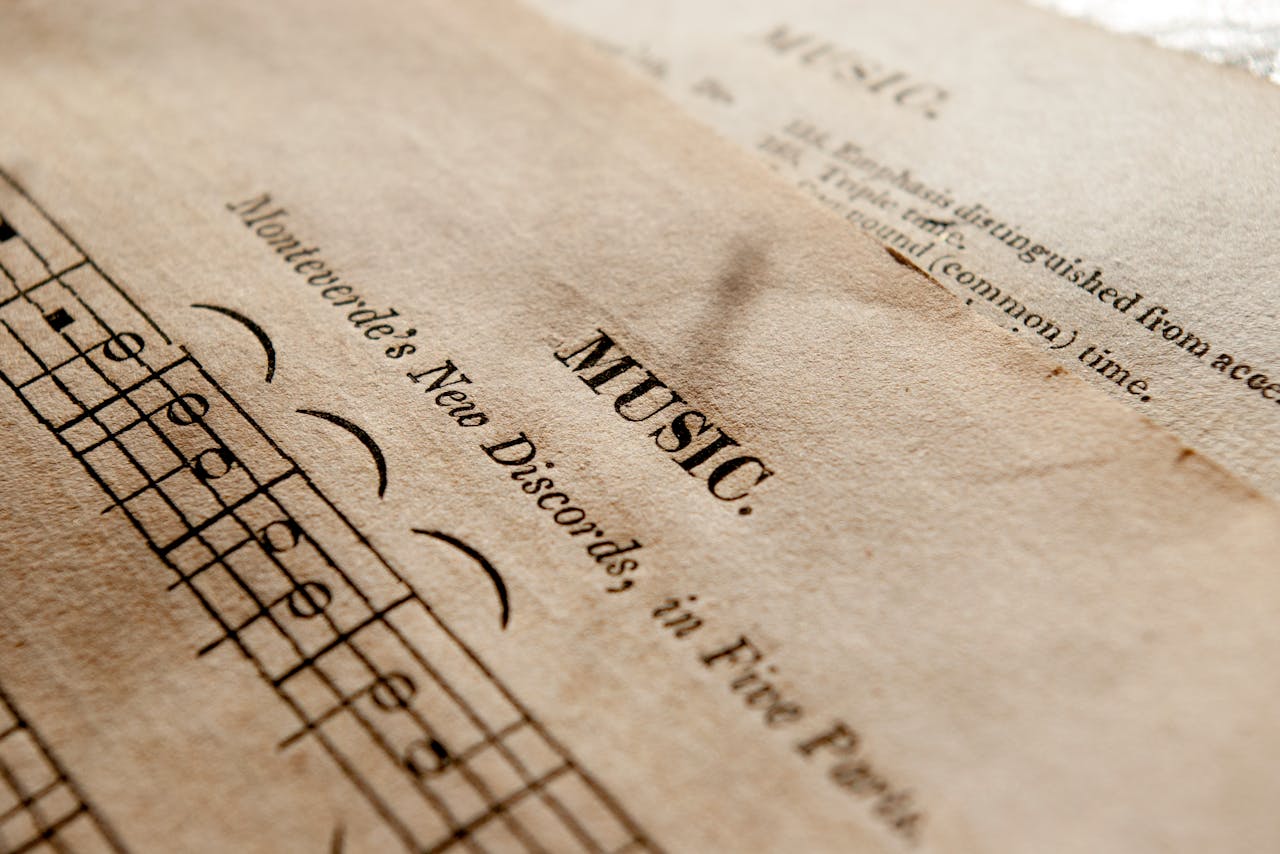 Detailed view of antique music sheets featuring notes and Monteverde's New Discords in sepia tone.